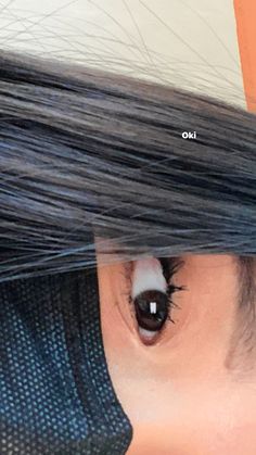 a woman with long black hair is looking through the hole in her eyeglasses