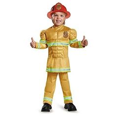 a young boy in a fireman costume with his hands out to the side, giving thumbs up