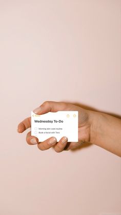 a hand holding a business card that says wednesday to do