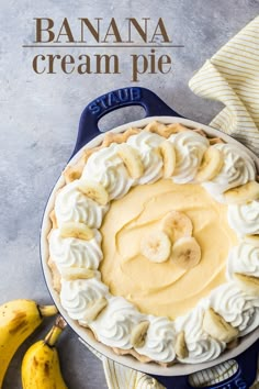 a banana cream pie sitting on top of a table next to bananas and a cloth