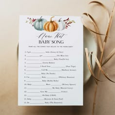 a baby shower game with pumpkins and leaves on the table next to a white plate