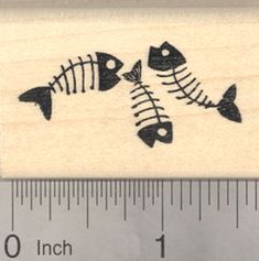 a rubber stamp with two fish on it and a ruler in front of the stamp