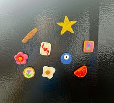 several different types of magnets on a black surface with flowers and other things around them