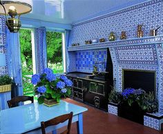 a kitchen with blue and white tiles on the wall, stove and table in front of it