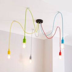 multicolored lights hanging from the ceiling in a room with white walls and flooring