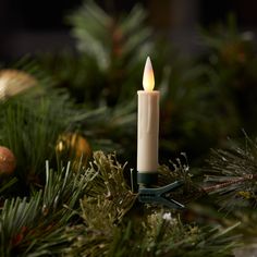 a lit candle sitting on top of a christmas tree