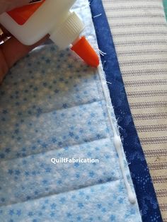 someone is using an orange and white sprayer on some fabric to make a quilt