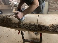 a man sanding wood with a power drill