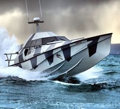 a white and black boat is in the water with waves coming up behind it on a cloudy day