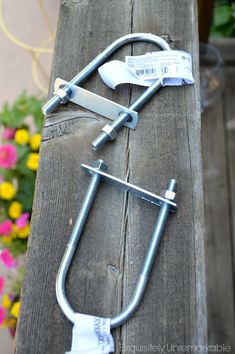 the handlebars are attached to the wooden bench with flowers in the back ground