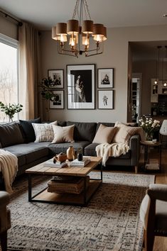 a living room filled with furniture and a chandelier hanging over the couches