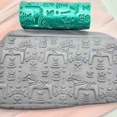 an elephant and giraffe pattern is on the back of a rubber mat with a green handle