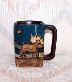 a ceramic coffee mug with an image of two moose in the night sky on it