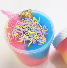 an ice cream container with sprinkles and a unicorn horn sticking out of it