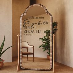 a mirror sitting on top of a table next to a potted plant and chair