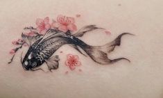 a woman's back with a fish and flowers on it