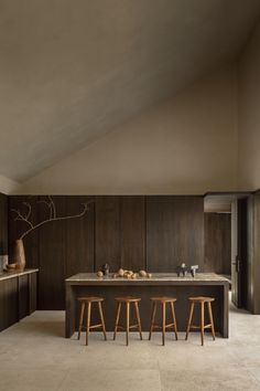 a kitchen with two stools next to an island and counter top in the middle