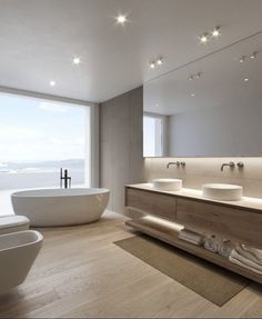 a bathroom with two sinks and a bathtub in front of a large window overlooking the ocean