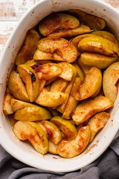 a white bowl filled with sliced apples on top of a table