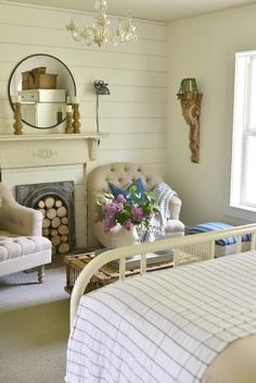 a bedroom with a bed, chair and fireplace in it's centerpieces