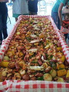 a large tray filled with lots of food on top of a checkered table cloth