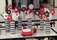 a table topped with vases filled with candy and decorations for a volleyball themed party