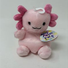 a pink stuffed animal with a tag on it's ear