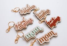 six different key chains with the word mom written on them, all in different colors