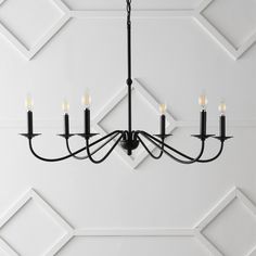 a black chandelier with five lights hanging from it's center and four arms