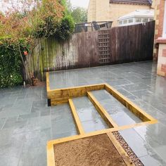 an outdoor patio with raised planters and gravel