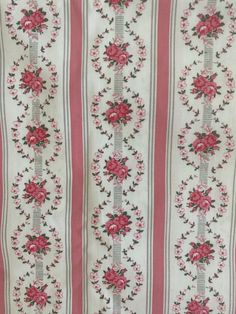 a pink and white striped fabric with flowers on it's side, in the middle of