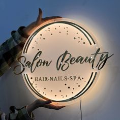 a person holding up a sign that says salon beauts hair and spa on it