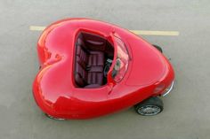 an overhead view of a red car in the middle of the road with its seats down