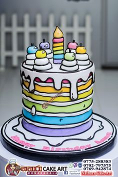 there is a cake that has been decorated with colorful icing and candles on it