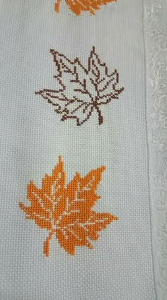 an orange and brown leaf on white fabric