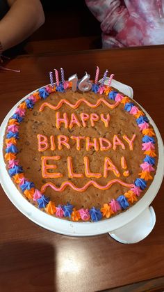 a birthday cake with the words happy birthday ella written on it and decorated with colorful icing