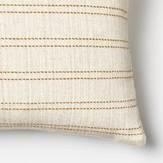 a white pillow with brown lines on the front and back, against a white background