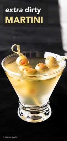 an extra dirty martini in a glass bowl with olives on the rim and text overlay that reads extra dirty martini