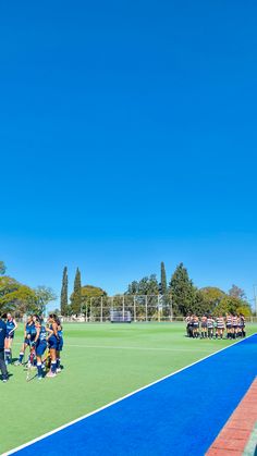 a group of people standing on top of a tennis court