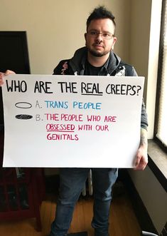 a man holding a sign that says who are the real crepes?