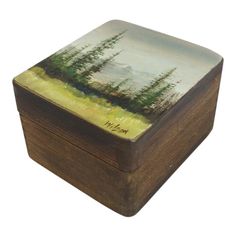 a small wooden box with trees painted on it