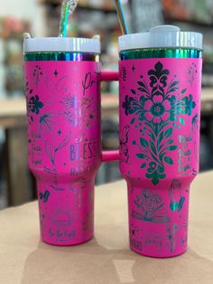 two pink coffee mugs sitting on top of a table