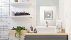 a bathroom with a sink, toilet and shelving unit on the wall above it