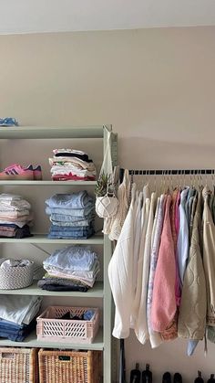 an organized closet with clothes and shoes hanging on the rack, next to a shelf full of folded shirts