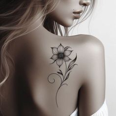 the back of a woman's shoulder with a flower tattoo on her left side