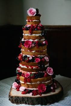 a multi layer cake with flowers and berries on it