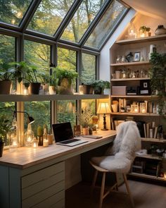 a desk with a laptop computer on top of it next to a window filled with potted plants