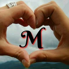 two hands making a heart shape with the letter m in it's middle and bottom