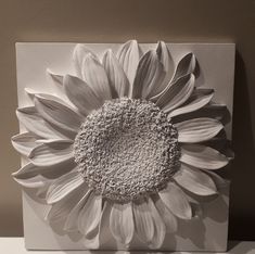 a sunflower is shown in black and white on the wall above a table top