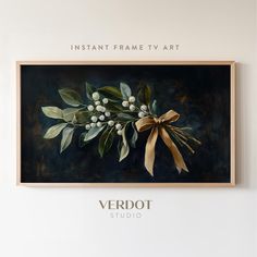 a painting hanging on the wall next to a vase with flowers and leaves in it